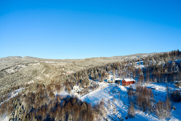 Drone photo from winter land Norway, Gol, Hallingdal. Shot in the cold in January in the blue hours early morning. Sun is rising and the frozen landscape is thawing.  © SteinOve