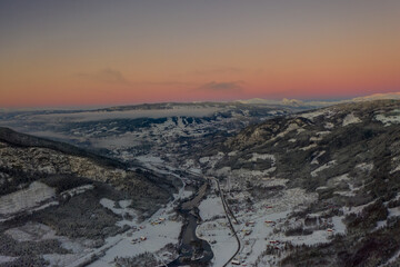 Drone photo from winter land Norway, Gol, Hallingdal. Shot in the cold in January in the blue hours early morning. Sun is rising and the frozen landscape is thawing.  © SteinOve