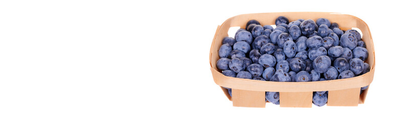 Fresh raw blueberry in wooden basket, isolated on white background.