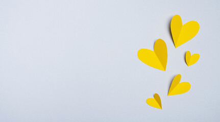 Valentines day. Yellow hearts made of paper on gray background. Minimal composition in trendy colors. Top view, flat lay, copy space