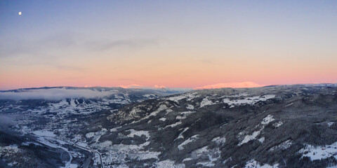 Drone photo from winter land Norway, Gol, Hallingdal. Shot in the cold in January in the blue hours early morning. Sun is rising and the frozen landscape is thawing. 