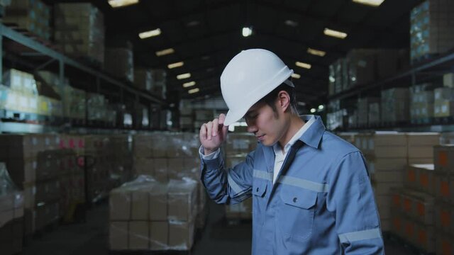 portrait of asian male professional enginner wearing uniform hardhat standing and smile with confident and cheerful in warehouse factory
