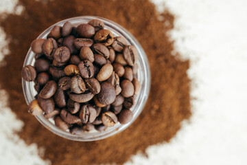 Freshly roasted coffee beans in a glass vessel top view, place for text