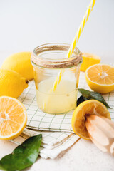 Freshly squeezed natural lemon juice in a glass jar on a white background