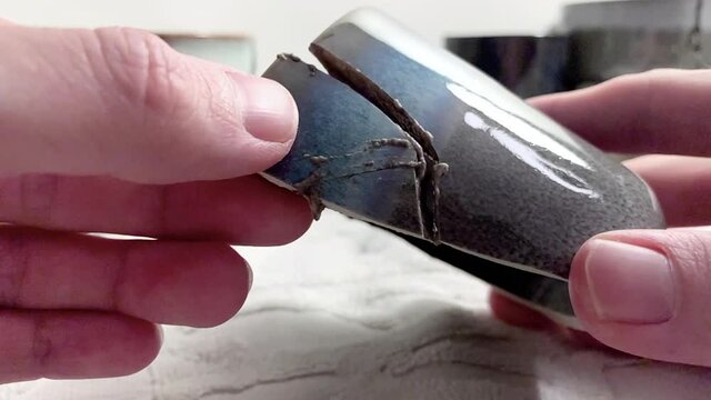 Artisan working on kintsugi process. Slow motion cinematic Kintsukuroi video. Rebuilding phase.