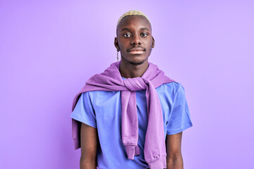african guy in casual shirt posing at camera isolated over purple background, calm