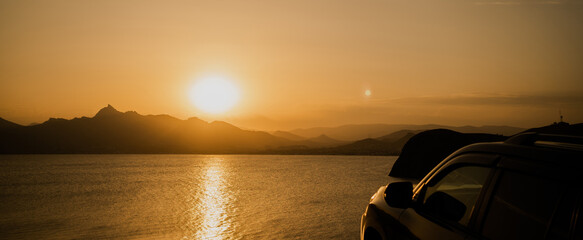 travel tourism by car on the edge of the mountain through the country in the mountains, sunset...