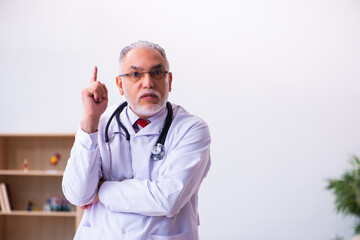 Old male doctor working in the clinic