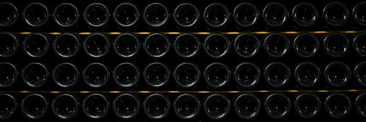 bottles of wine and champagne are stored underground in the winery. texture background. wine cellar.