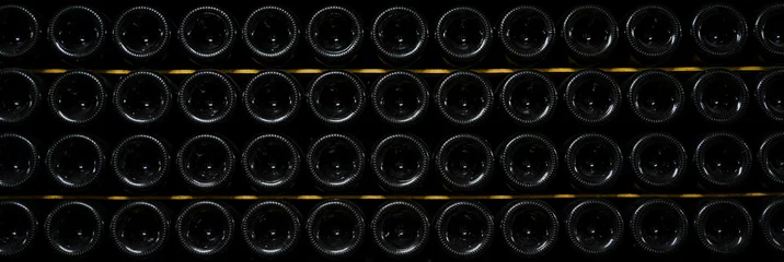Poster bottles of wine and champagne are stored underground in the winery. texture background. wine cellar. © muse studio