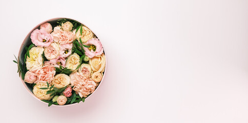Luxury beautiful flowers in a hat round box on the pink background with copy space. Gift or present on St. Valentines Day, 8 March, Mother Day, wedding