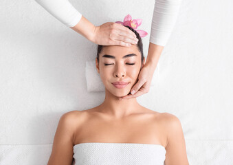 Beauty And Wellness. Young Asian Woman Enjoying Face Lifting Massage In Spa