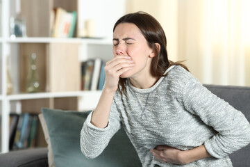 Woman with a stomach ache about to vomit at home