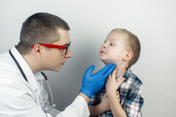 A pediatrician examines a boy who complains of a sore throat. Diagnosis of tracheal diseases....