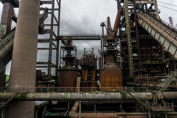 Fototapeta na wymiar Blast Furnace in Dortmund, Germany. The coal mining and steel in the region collapsed and nowadays this colossal buildings are abandoned and unused.