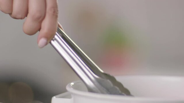 Tongs Pulling Ramen Noodles Out of a Bowl