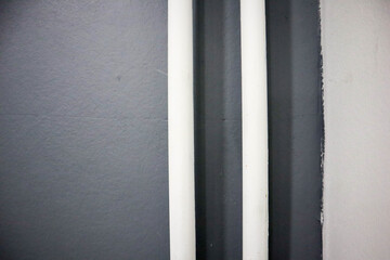 white pipes on a gray wall background

