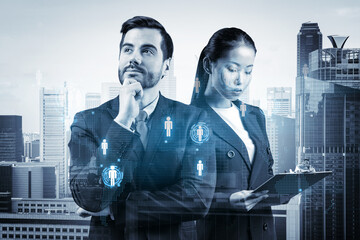 Businessman and businesswoman as a SMM specialists thinking about development of social media marketing strategy to achieve business goals. Hologram icons over Singapore background.