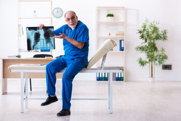 Old male doctor radiologist working in the hospital