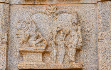 Hampi, Karnataka, India - November 4, 2013: Hazara Rama Temple. Closeup of beige stone damaged sculpture on wall featuring group of royals.