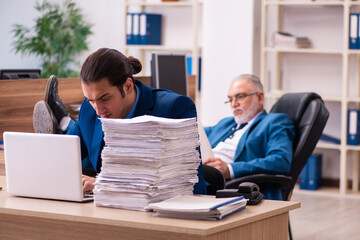 Obraz premium Old male boss and his young male assistant in bullying concept