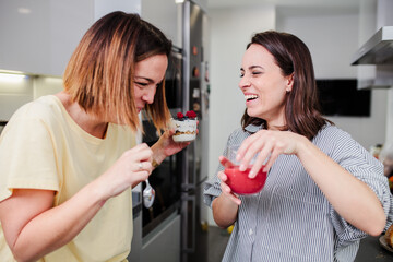 Women preparing healthy food playing with vegetables in kitchen having fun concept dieting nutrition.