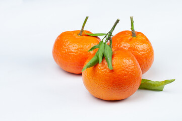 a group of tangerines with green leaves