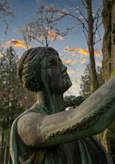 trauernde Frau sieht sich den Grabstein an