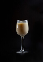 milk in a glass on a black background