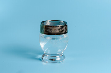 Water in a beautiful glass on a blue background
