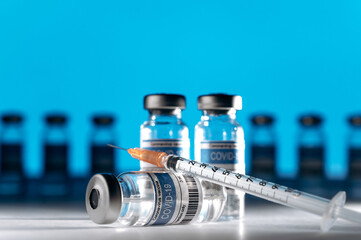 Medical ampoules with a coronavirus vaccine and a syringe in a laboratory. COVID-19 worldwide vaccination. Medicine and healthcare prevention concept