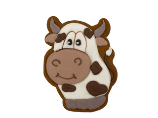 Christmas gingerbread on a white background. The cow is the symbol of the year. Brown homemade cookies in colored icing sugar. New year ornament handmade decoration.