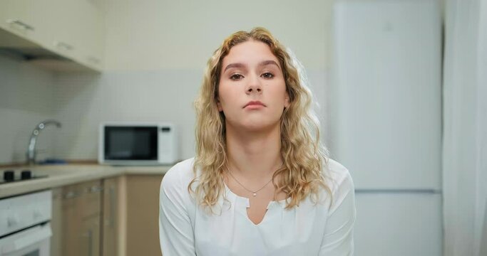 Curly haired freelancer looks into computer camera searching for distant work and nods listening to employer at online interview