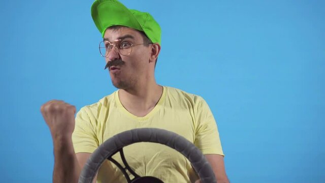 Angry man swears at the wheel on a blue background of slow mo, isolate