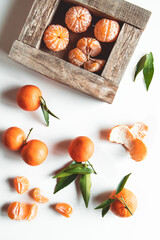 tangerines with fresh leaves in wooden box isolated on white, isolated on a white, top view