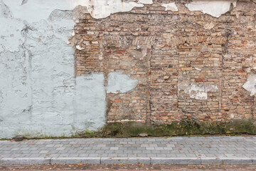 Urban street background. Old grunge obsolete brick wall and pavement