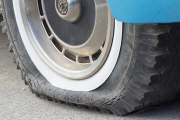 Close-up of a flat tire of a car. Car breakdown during travel. Retro style.