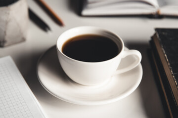 Office desk table with supplies, coffee cup and flower. Top view