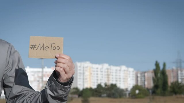Harassment. Female hand holding a # Me Too sign