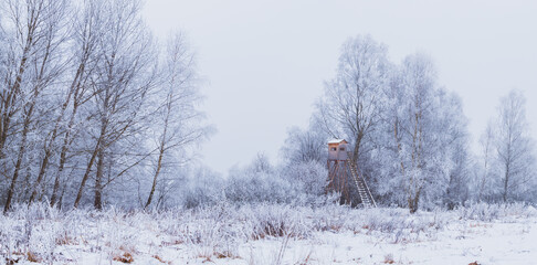 winter landscape with snow, hunting blind near the forest and meadow