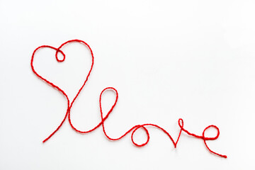 Valentine's day concept. Red heart and word love made from woolen rope on white background with...