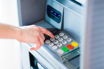 Hand using an ATM bank machine. 