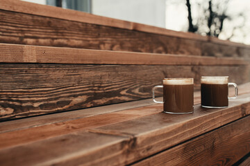 Two cups of coffee in the wooden brown terrace background
