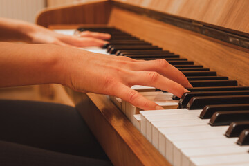 Obraz premium pianist playing the piano, close up view of hands and keys, side view