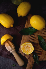 Ripe juicy organic lemons on a wooden board, dark background