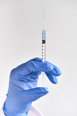 Vaccine against Covid-19 caused by novel coronavirus Sars-CoV-2. Hand in blue protective gloves...