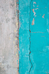Peeling paint on the wall. Old concrete wall with cracked flaking paint. Weathered rough painted surface with patterns of cracks and peeling. Grunge texture for background and design. High resolution.