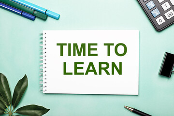 Fototapeta premium TIME TO LEARN is written on a white sheet on a blue background near the stationery and the Scheffler sheet. Call to action. Motivational concept