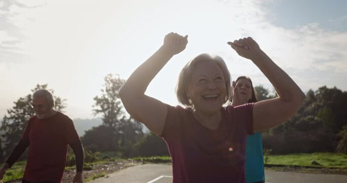 Senior woman celebrating after scoring basketball with group of friends