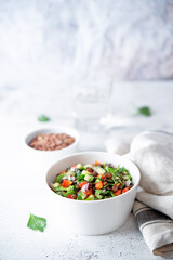 Green lentil red bell pepper cucumber parsley salad in a bowl